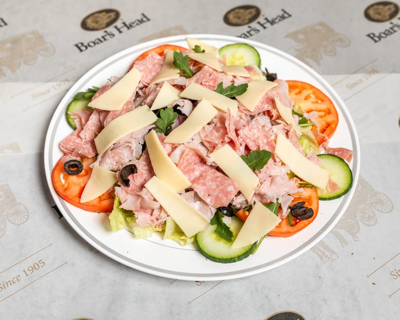 Boar's Head chef salad with sliced meats, cheese, tomatoes, cucumbers, olives, and greens.